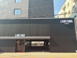 Un edificio moderno con un cartel que dice 'LANTANA HOTEL' en la entrada.
