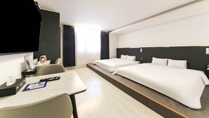 A hotel room with two beds, a desk, a chair, a TV, and a window with curtains. - Gwangju Hotel Lantana - Hanam (Gwangju)