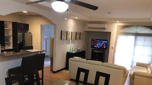 A modern living room with a dining area, a sofa, a TV, and a ceiling fan. - Suite F, 2BR / 2BA in San Pedro Garza García, Centrito Valle (San Pedro Garza García)