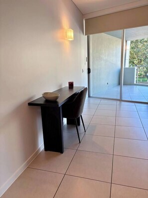 Un interior moderno con diseño minimalista, que presenta un comedor, un tazón, una silla y una lámpara fijada a la pared.