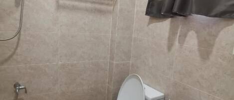A bathroom with a toilet, bidet, shower, and towel rack.