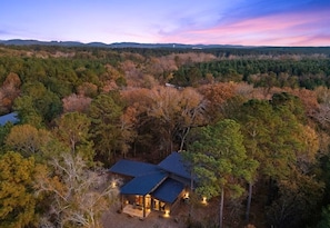 A house surrounded by forest with a view of distant hills. - NEW! Heated Pool, Hot Tub, Outdoor Lounge, Games (Broken Bow)