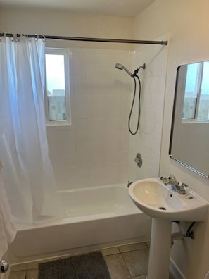 A bathroom with a bathtub, shower, and sink. - Spacious 1BR Apt, gated parking-near downtown (Sacramento)