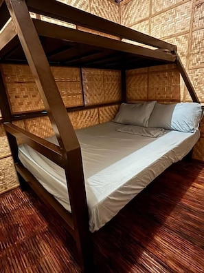 A bunk bed with a wooden frame and a woven wall backdrop.