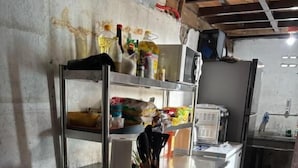 Une cuisine équipée d’appareils électroménagers en acier inoxydable, d’une cuisinière à gaz et de divers ustensiles de cuisine rangés sur des étagères.