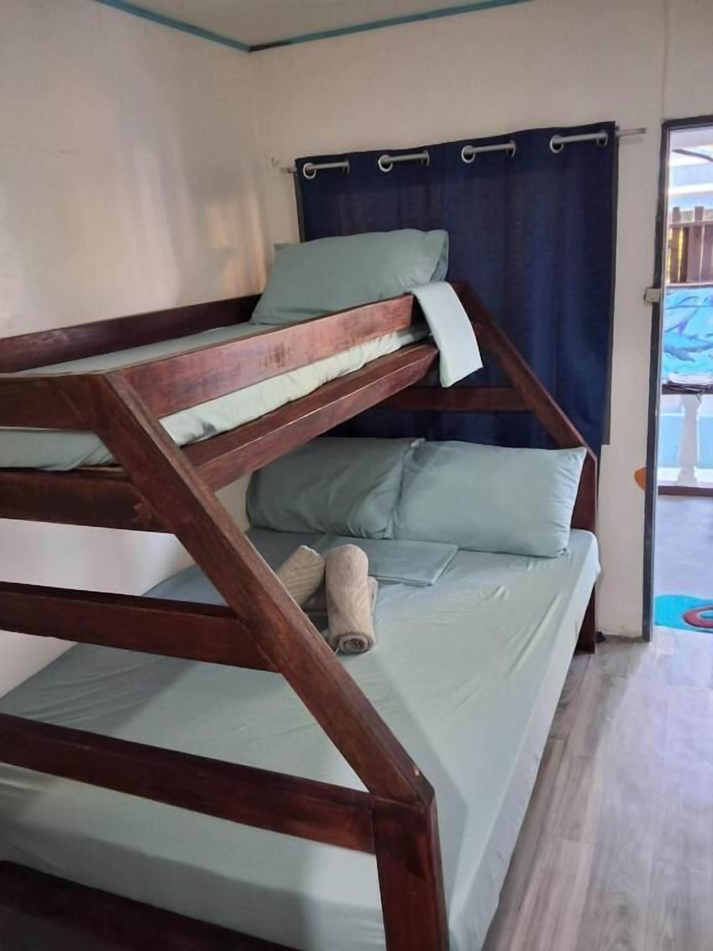 Una cama litera con estructura de madera y ropa de cama azul claro.