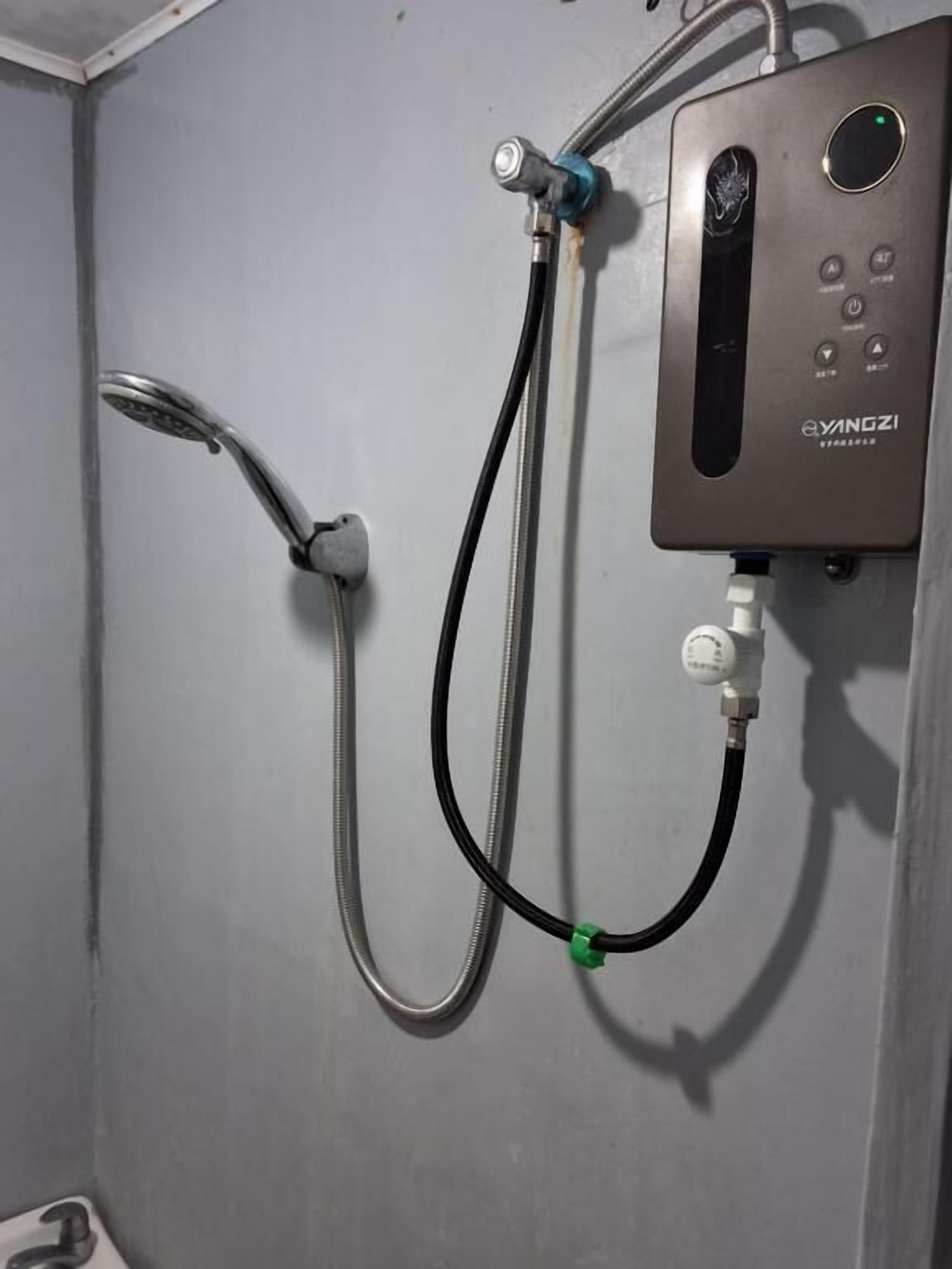 Una ducha con cabezal de ducha manual y panel de control con botones y un dial.