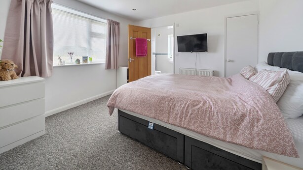 A bedroom with a bed, a television, a window with curtains, a radiator, and a teddy bear on a shelf. - Sea Palling 2 bed /2 bath beach apartment Sleeps 4 (Norwich)