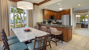 A modern kitchen with wooden cabinets, a stainless steel refrigerator, and a marble island. - Marriott's Maui Ocean Club Walk to Beach & Whalers Village (Lahaina)