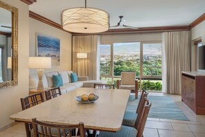 A dining area with a table, chairs, and a bowl of fruit. There is a sofa and a television in the room. - Marriott's Maui Ocean Club Walk to Beach & Whalers Village (Lahaina)