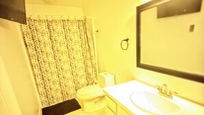 A bathroom with a white sink, a mirror, a toilet, and a shower curtain. - 2-bedroom townhome in terrific Attleboro  close to Gillette and Foxwoods (Attleboro)