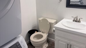A bathroom with a toilet, sink, and a washing machine. - 2-bedroom townhome in terrific Attleboro  close to Gillette and Foxwoods (Attleboro)