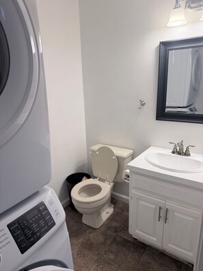 A bathroom with a toilet, sink, and a washing machine. - 2-bedroom townhome in terrific Attleboro  close to Gillette and Foxwoods (Attleboro)