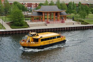 A yellow boat with 'CHICAGO WATERTAXI' written on the side, moving on a river.