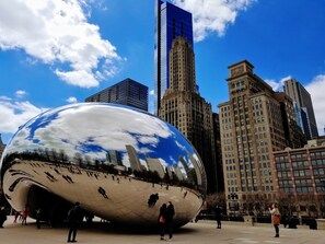 A spherical sculpture in an urban plaza with modern buildings in the background.