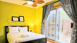 A bed with white linens, a bedside lamp, and a window with patterned curtains. - Townhome 3 bedroom 2 bath with Parking - near McCormick Place , Chinatown Sox (Chicago)