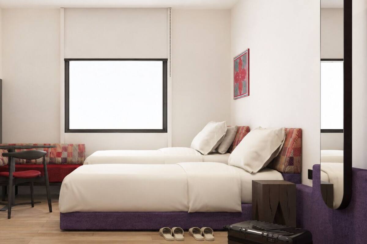 Un dormitorio moderno con cama, escritorio, silla, televisor y ventana.