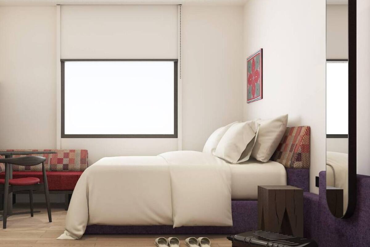 Un dormitorio moderno con una cama, un escritorio y una silla.