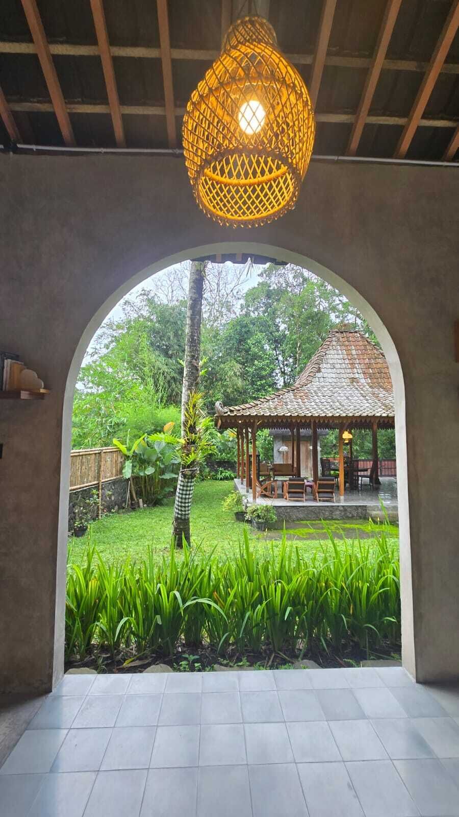 An arched doorway leading to a garden with a gazebo.