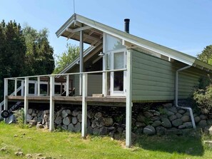 Une maison de plain-pied dotée d’un porche couvert, d’une cheminée et de fondations en pierre.