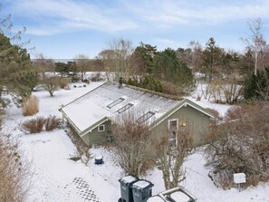 Une maison avec un toit en pente, un petit porche et une boîte aux lettres.