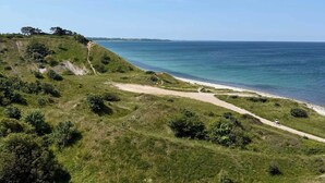 A coastal landscape with a dirt path leading to a beach. - 4 Star Holiday Home in Nykobing Sj (Nykobing Sjaelland)