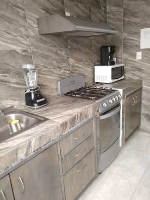A kitchen with a gas stove, microwave, blender, and stainless steel cabinets. - Wonderful home for your rest and/or work (Santiago de Querétaro)