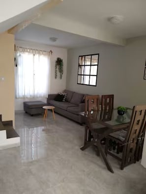 A living room with a sofa, a small round table, and a dining table with chairs. - Wonderful home for your rest and/or work (Santiago de Querétaro)