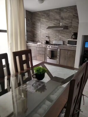 A modern kitchen with a stove, microwave, and cabinets. - Wonderful home for your rest and/or work (Santiago de Querétaro)