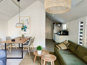 Um apartamento moderno com sala de jantar, cozinha e sala de estar.