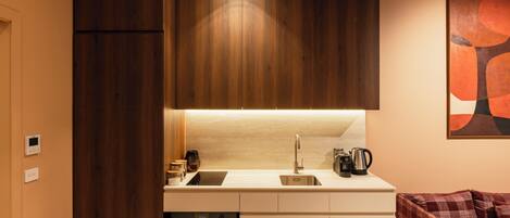 A modern kitchen with wooden cabinets, a stainless steel sink, and a coffee maker.