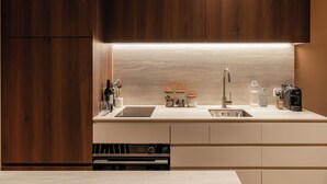A modern kitchen with wooden cabinets, a stainless steel sink, and a built-in wine cooler. - The Lane House (Melbourne)