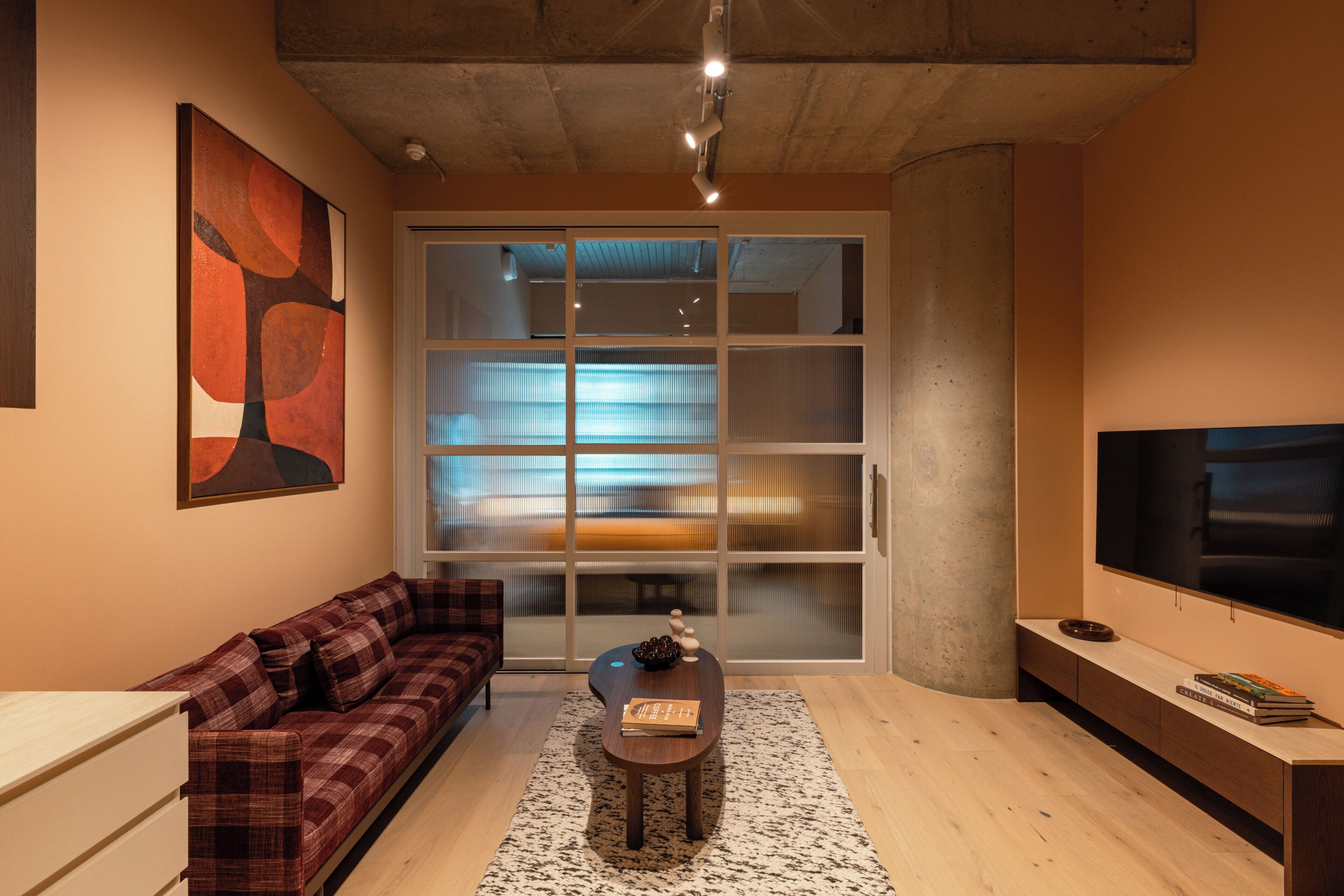Una sala de estar moderna con un sofá, una mesa de centro y una televisión.