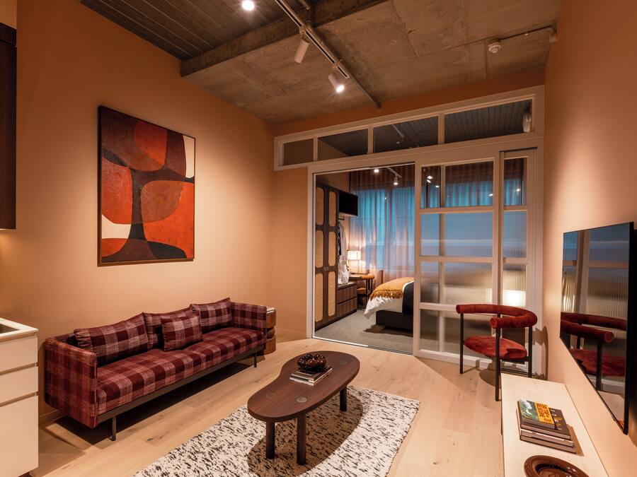 A modern living room with a sofa, coffee table, and a large abstract painting.