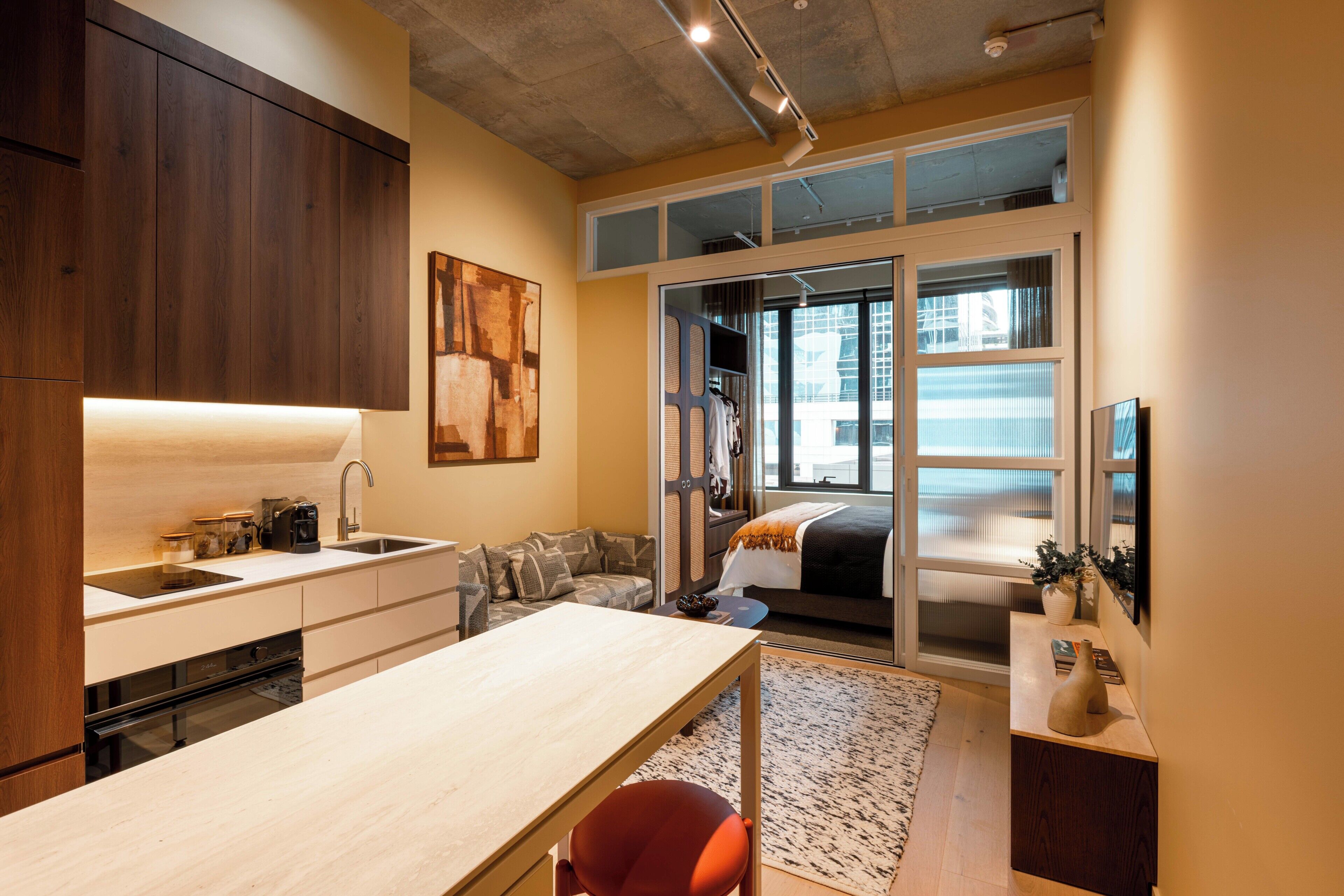 A modern kitchen with a built-in oven, a coffee machine, and a sink.