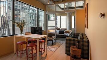 A modern interior with a dining area, seating, and a view of the city.