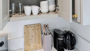 Ein Küchenschrank mit Regalen, auf denen Teller, Schüsseln und Gläser stehen.