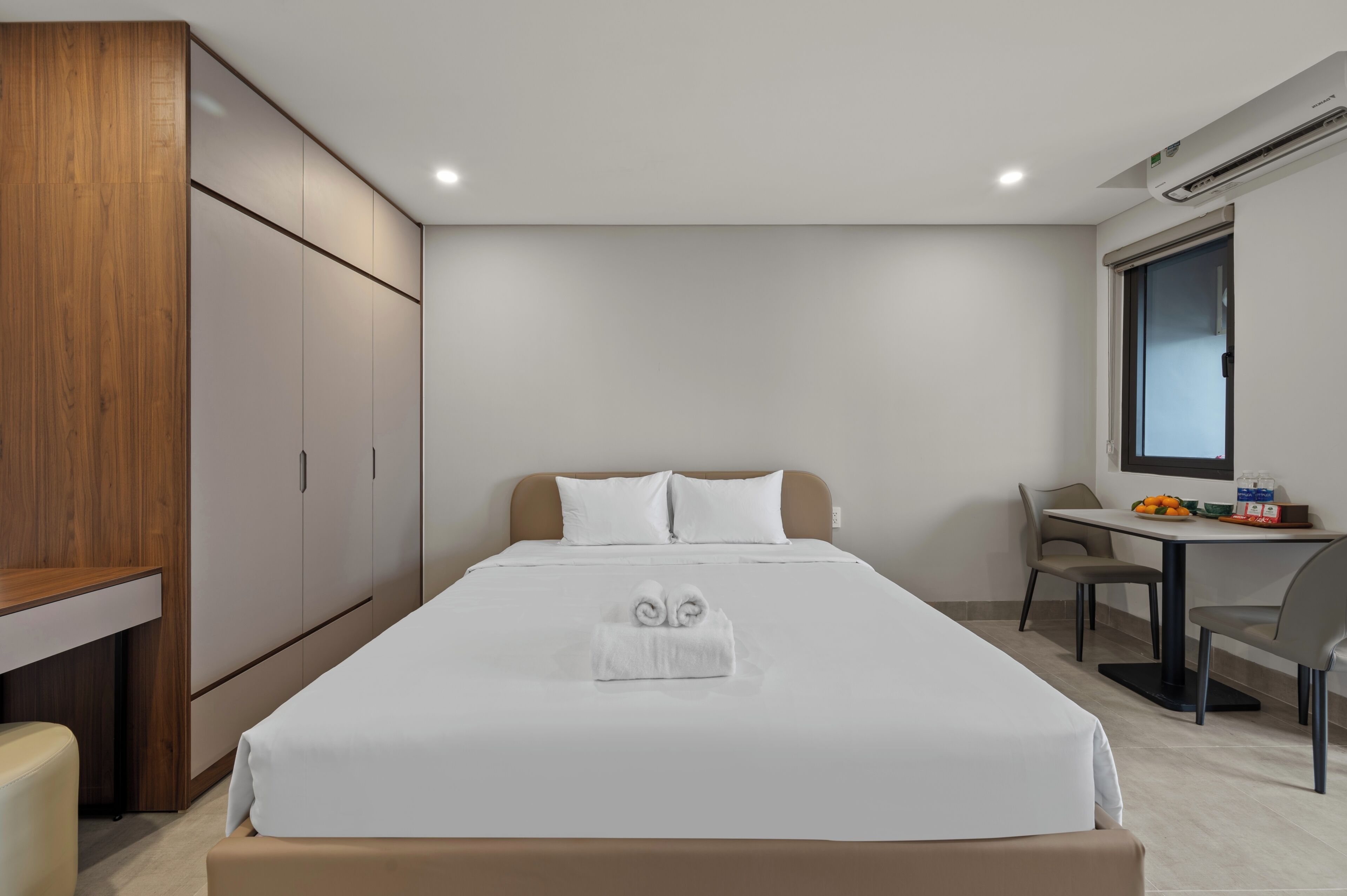 Una camera d'albergo con un letto, una scrivania e un armadio.