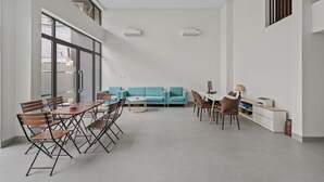 Una habitación amplia con zona de comedor, un sofá y una pequeña mesa.