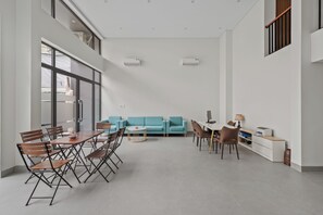 Una habitación amplia con zona de comedor, un sofá y una pequeña mesa.