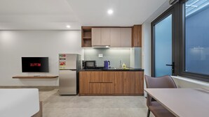 Una cocina moderna con armarios de madera, microondas integrado y refrigerador.