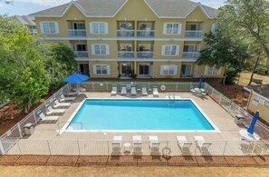 A multi-story building with a swimming pool surrounded by lounge chairs and umbrellas. - Beautiful 2 bedroom/2 bath condo in Santa Rosa Beach (Santa Rosa Beach)