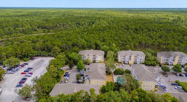 A residential area with multiple apartment buildings, a parking lot, and surrounding forested land. - Beautiful 2 bedroom/2 bath condo in Santa Rosa Beach (Santa Rosa Beach)