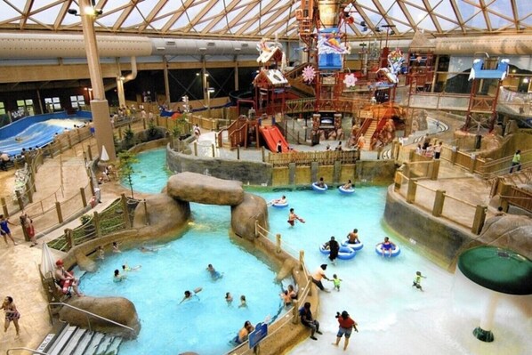 An indoor water park with multiple pools, slides, and play structures. - Waterfront Paradise | Sauna, Hot Tub, Fire Pit, Private Dock & Water Crafts (Pocono Summit)