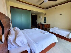 Habitació d'hotel amb dos llits, una taula de treball i una cadira.