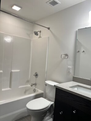 Ein modernes Badezimmer mit Badewanne, Toilette und Waschbecken.