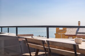 A balcony with a table and chairs, overlooking a coastal view. - GuestReady - Fuentebravia with terrace and pool (El Puerto de Santa María)