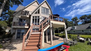 A multi-story house with a balcony, a staircase, and a kayak. - Lakeview on Magician- lakefront luxury (Dowagiac)