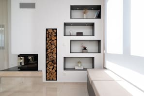 Ein modernes Wohnzimmer mit Kamin, Einbauschränken und einem großen Fenster.