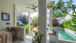 A modern outdoor patio with a pool, seating area, and potted plants. - Casa Mia Balangan by Betterplace (Jimbaran)